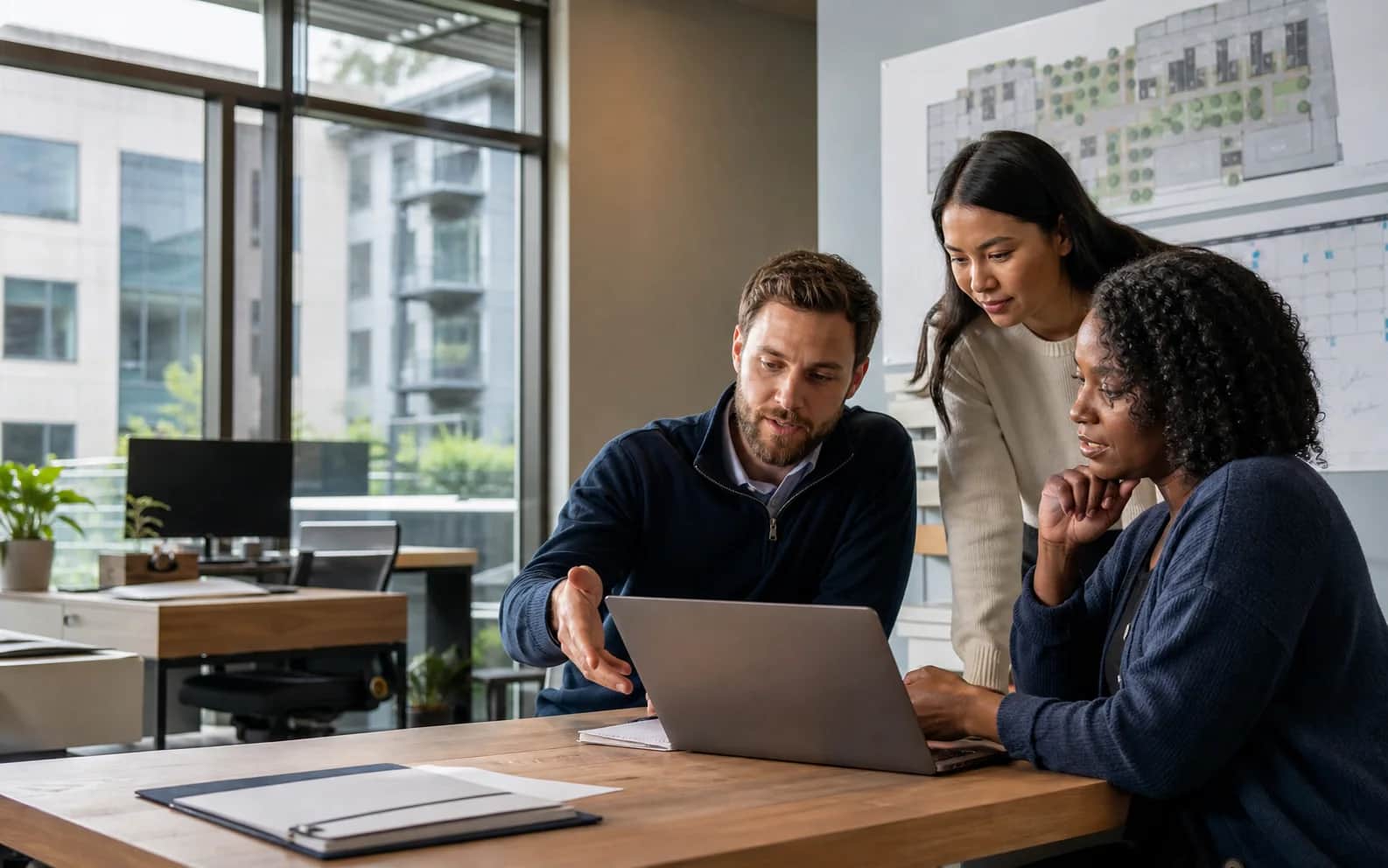 Property management professionals reviewing an operational workflow with an IT specialist